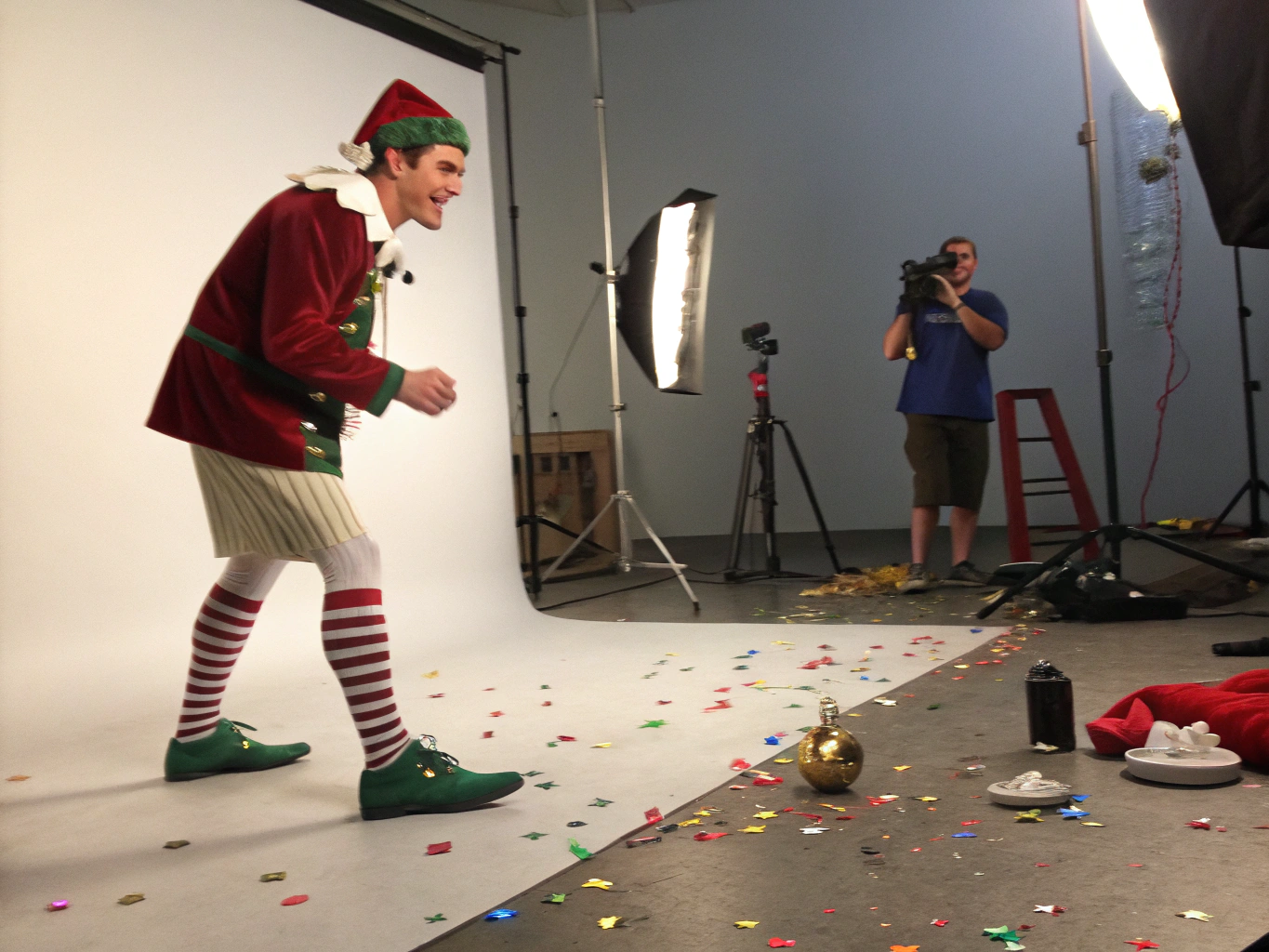 Men’s elf costume elements with confetti on blurred gradient background, festive and playful.